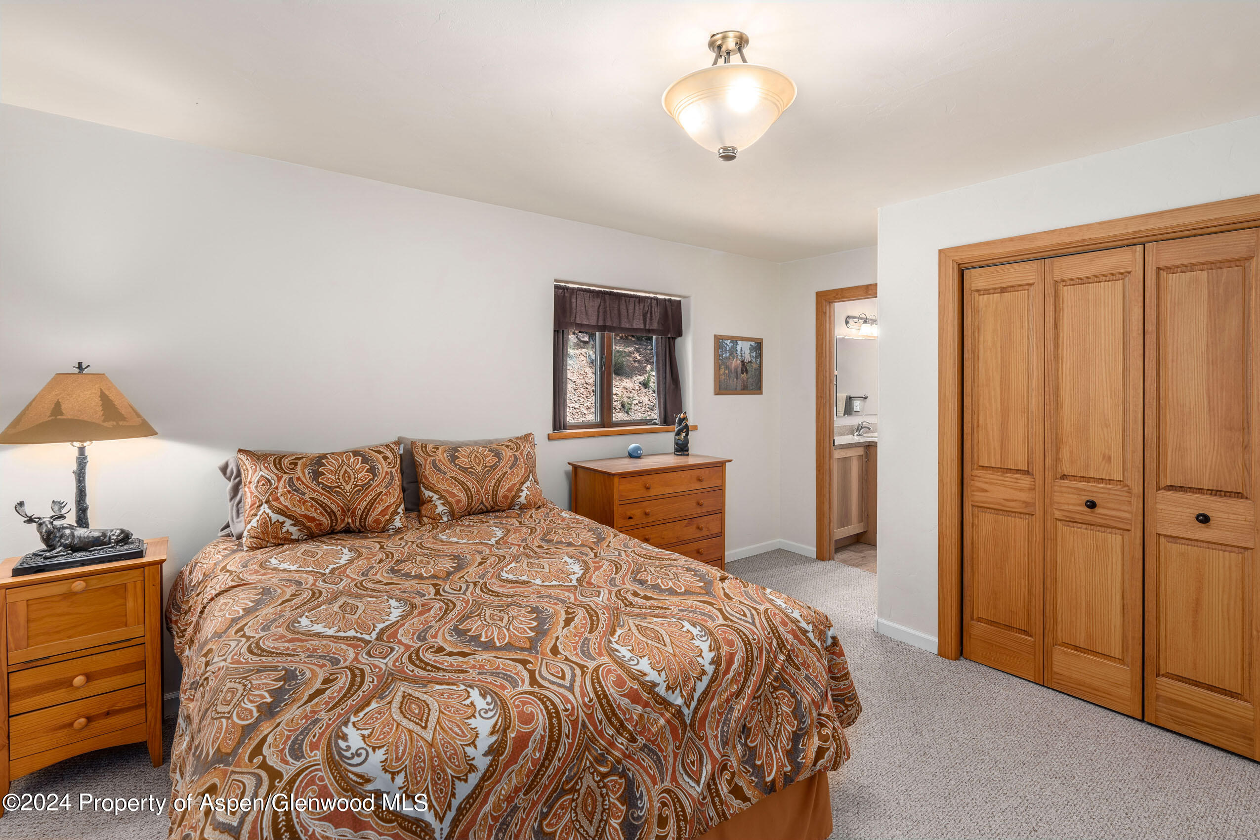 299 Knight Road Basalt, CO 81621 - Photo 24 of 48 a bedroom with a large bed and a chandelier