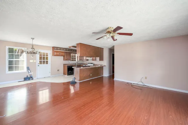 a view of a kitchen with wooden floor and a ceiling fan