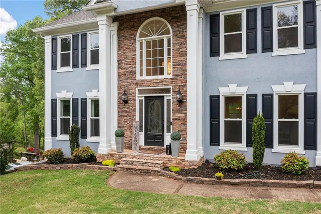 front view of a brick house next to a yard