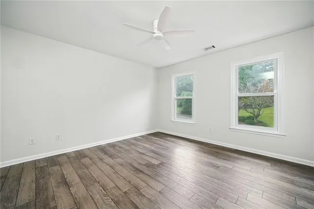a view of an empty room with wooden floor