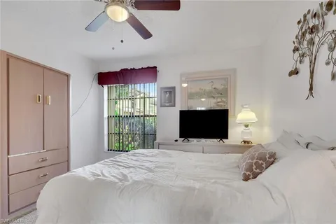 a bedroom with a bed mirror and window