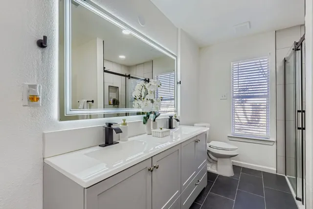 a bathroom with a sink toilet and mirror