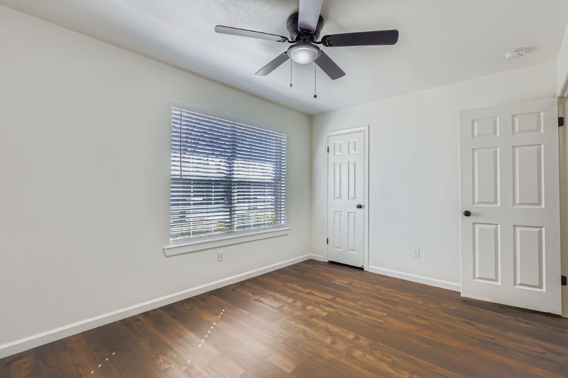 108 Susana Drive Georgetown, TX 78628 - Photo 22 of 26 an empty room with wooden floor ceiling fan and windows