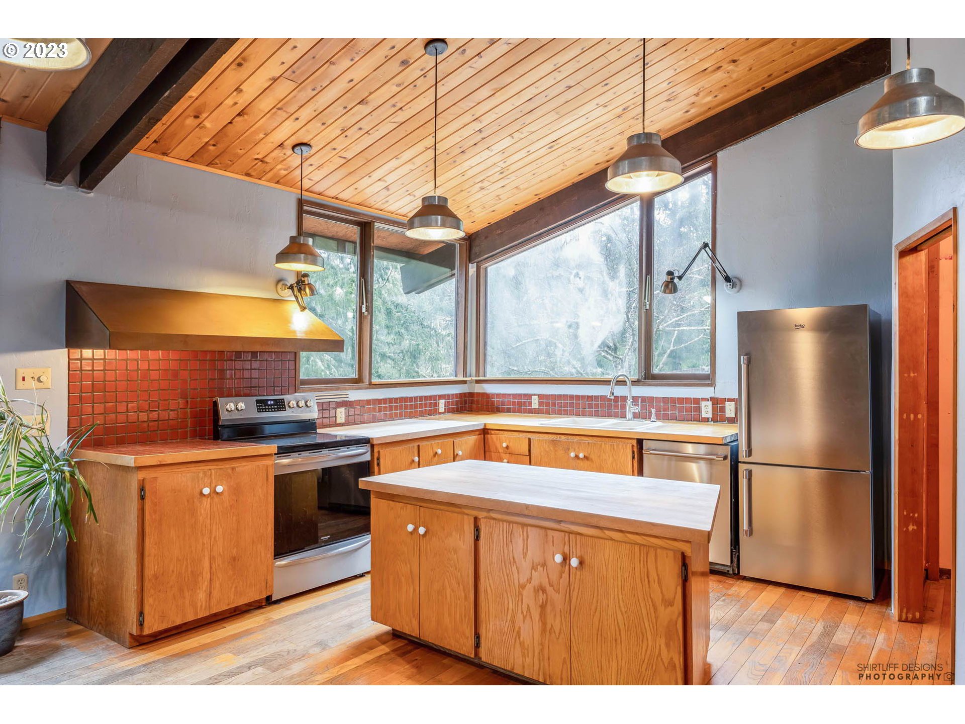 27313 Briggs Hill Road Eugene, OR 97405 - Photo 15 of 48 a kitchen with stainless steel appliances granite countertop a refrigerator a sink dishwasher a stove and white countertops with wooden floor