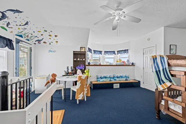 a view of a bedroom with baby crib and hanging chair