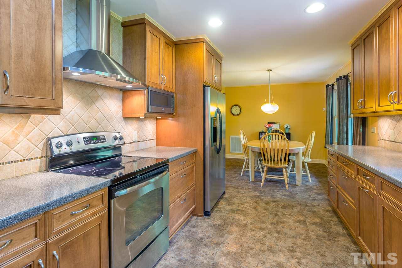 5113 Wickham Road Raleigh, NC 27606 - Photo 13 of 25 a kitchen with stainless steel appliances granite countertop table chairs sink and cabinets