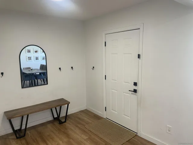 a view of a room with wooden floor and a table