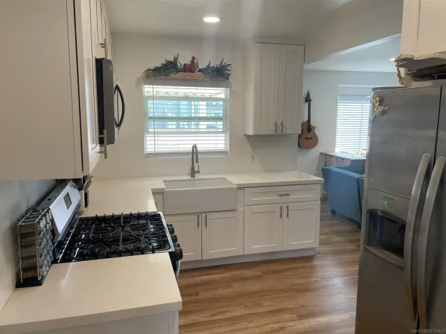 a kitchen with white cabinets and a stove