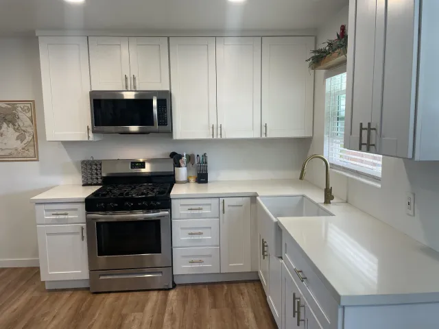 a kitchen with stainless steel appliances granite countertop a sink stove and microwave