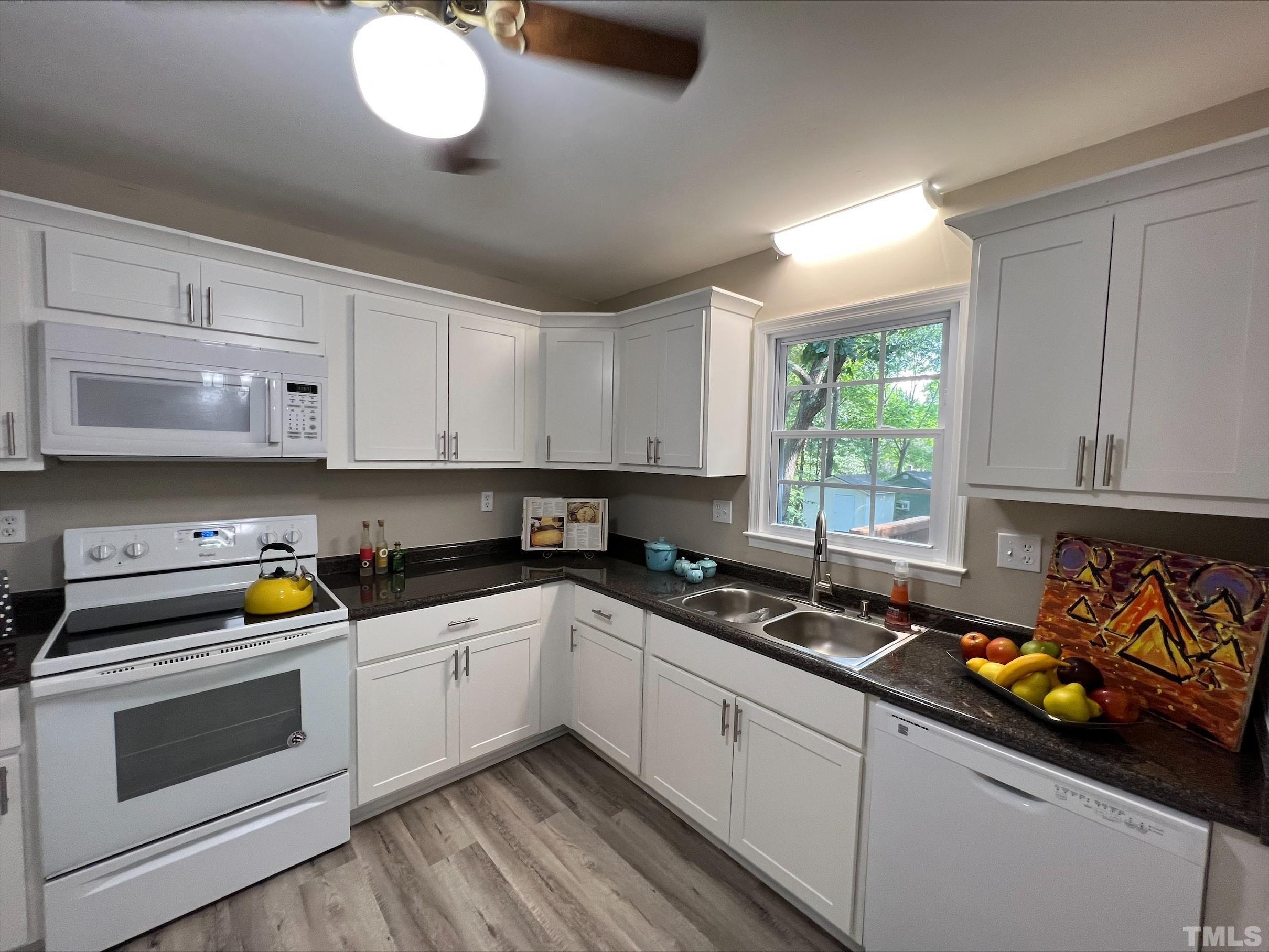 605 Sawmill Road Raleigh, NC 27615 - Photo 9 of 26 a kitchen with stainless steel appliances a stove a sink and a white cabinets