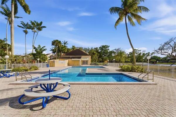 a view of a swimming pool with a lounge chair and tables