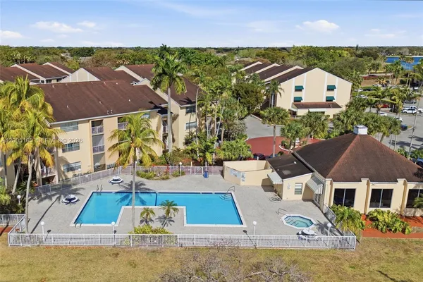 an aerial view of residential houses with outdoor space and swimming pool