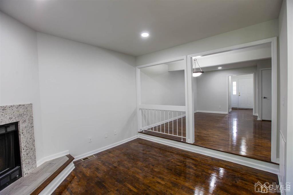 3004 Hana Road Edison, NJ 08817 - Photo 6 of 14 a view of a hallway with wooden floor and a fireplace