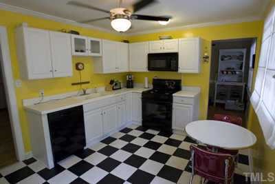 2260 Rumson Road Raleigh, NC 27610 - Photo 5 of 12 a kitchen with a sink a stove cabinets and a refrigerator