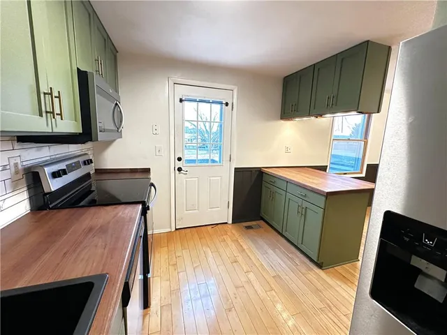 a kitchen with stainless steel appliances granite countertop a stove a sink and a refrigerator