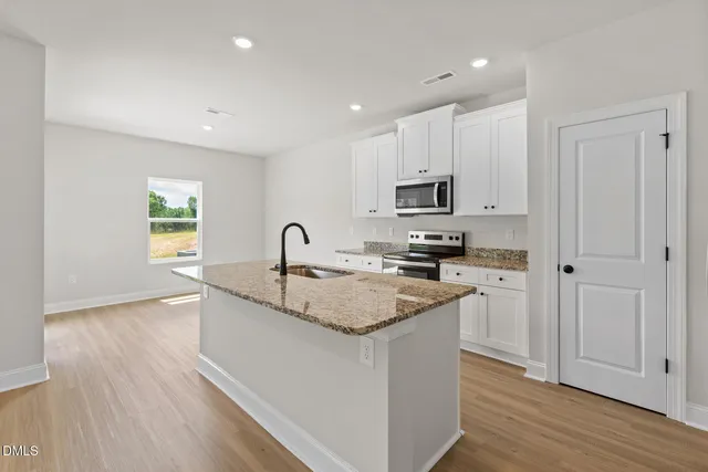 a kitchen with granite countertop a sink and a stove top oven