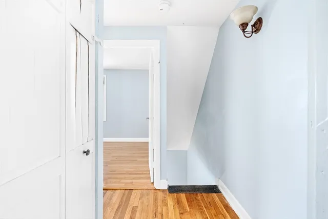 a view of a hallway with wooden floor and entryway
