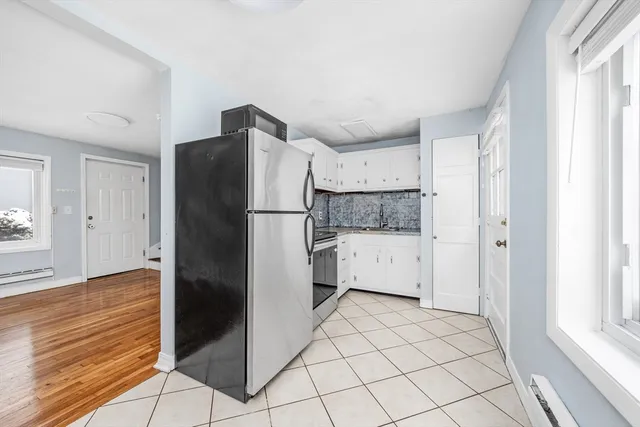 a kitchen with a refrigerator and white cabinets