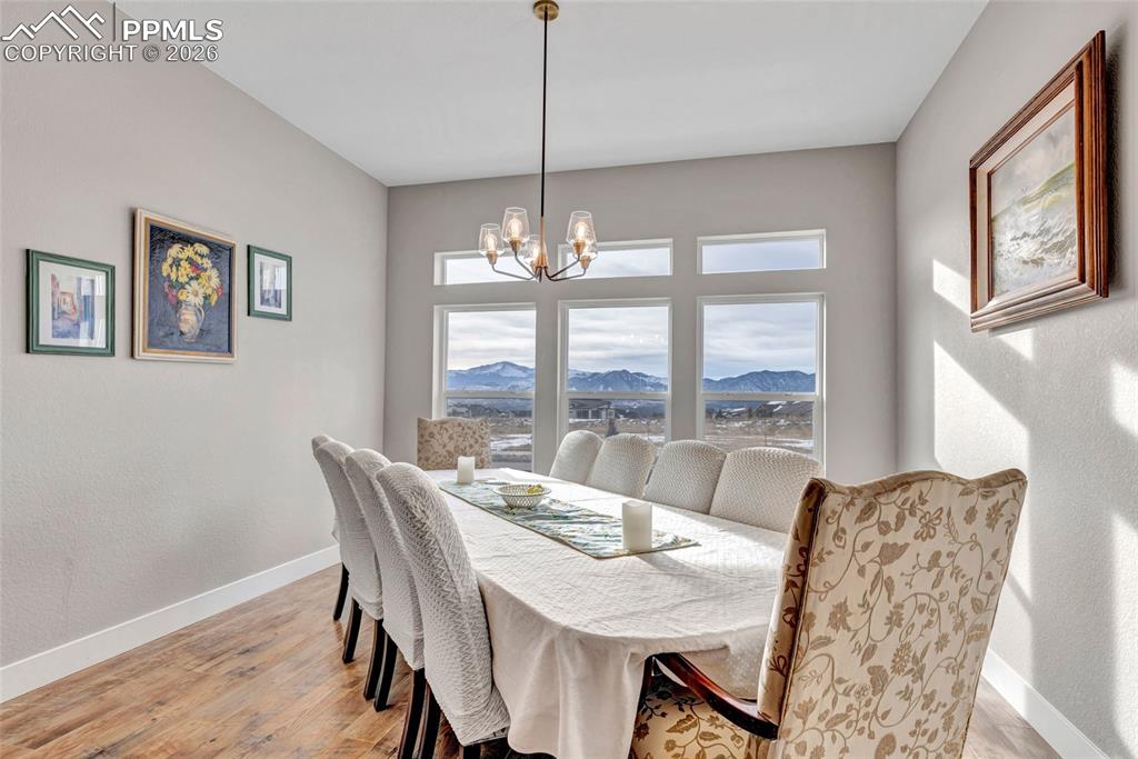 2402 Parma Court Colorado Springs, CO 80921 - Photo 18 of 45 a view of a dining room with furniture large windows and wooden floor