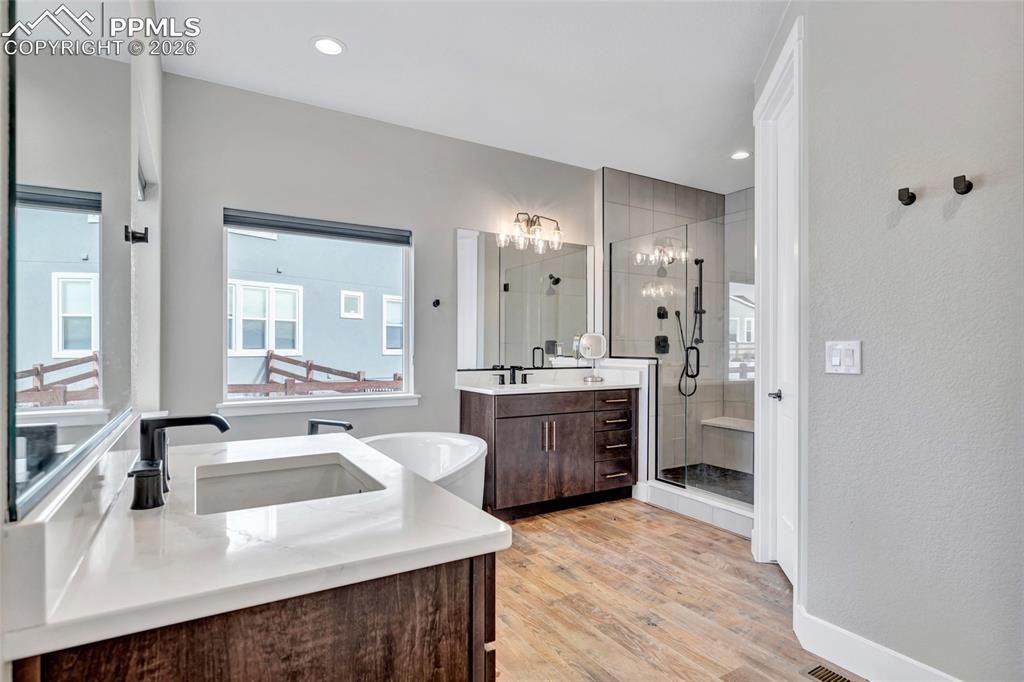 2402 Parma Court Colorado Springs, CO 80921 - Photo 25 of 45 a large white kitchen with a sink dishwasher a stove and a refrigerator with wooden floor
