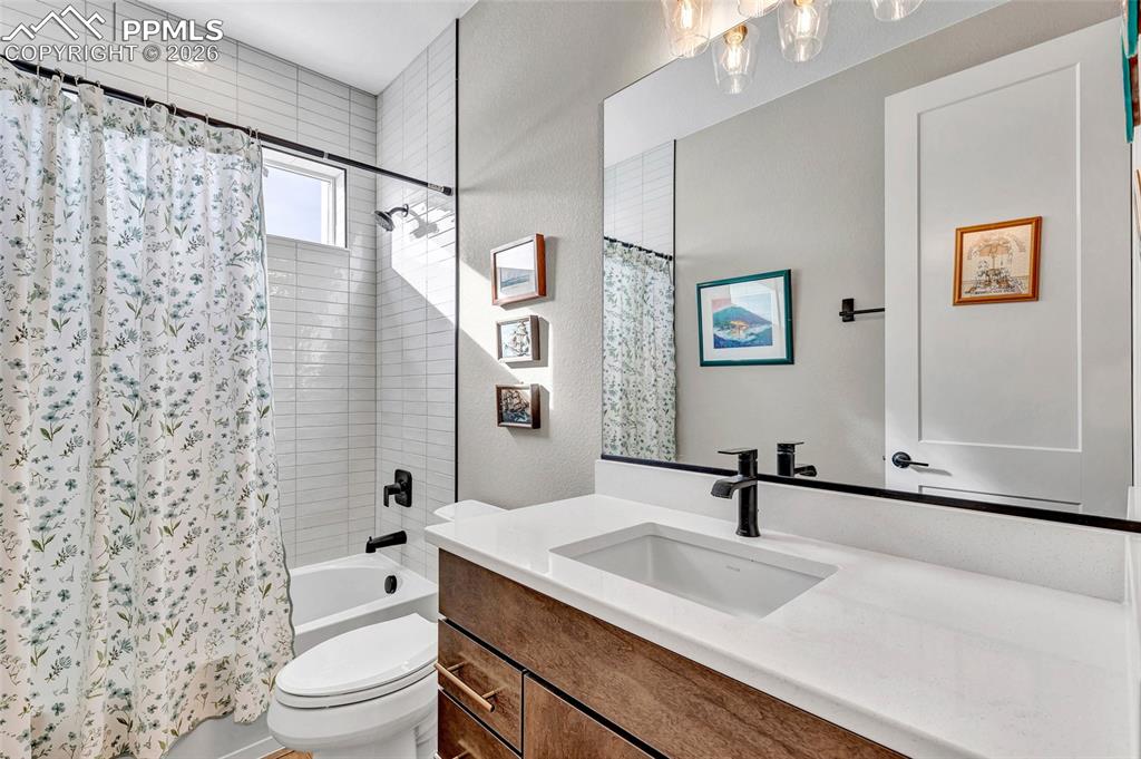 2402 Parma Court Colorado Springs, CO 80921 - Photo 41 of 45 a bathroom with a granite countertop sink a toilet and shower