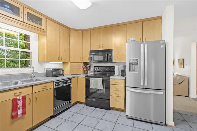a kitchen with stainless steel appliances granite countertop a refrigerator sink and stove