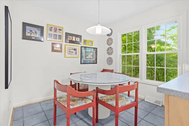 a view of a dining room with furniture large windows and a chandelier