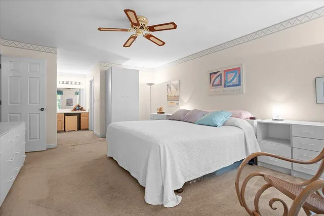 a spacious bedroom with a bed and a chandelier