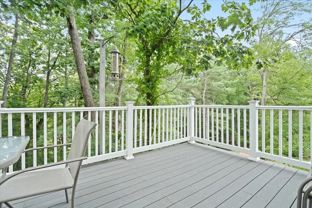 a balcony with wooden floor table and chairs