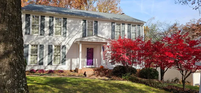 a view of house with outdoor space and trees around