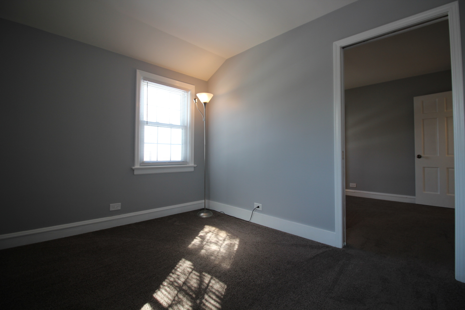 5237 North Olcott Avenue Chicago, IL 60656 - Photo 13 of 26 an empty room with wooden floor and windows with curtains