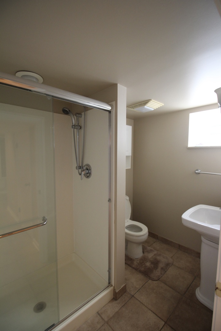 5237 North Olcott Avenue Chicago, IL 60656 - Photo 22 of 26 a bathroom with a granite countertop toilet and a shower