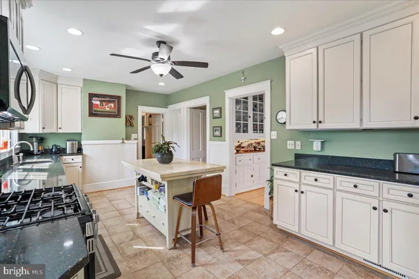 a kitchen with granite countertop a sink a stove and cabinets