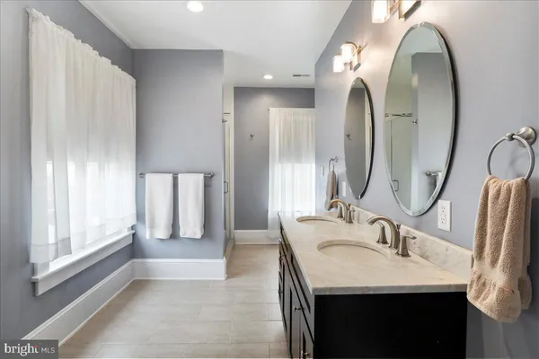 a bathroom with a double vanity sink and a mirror