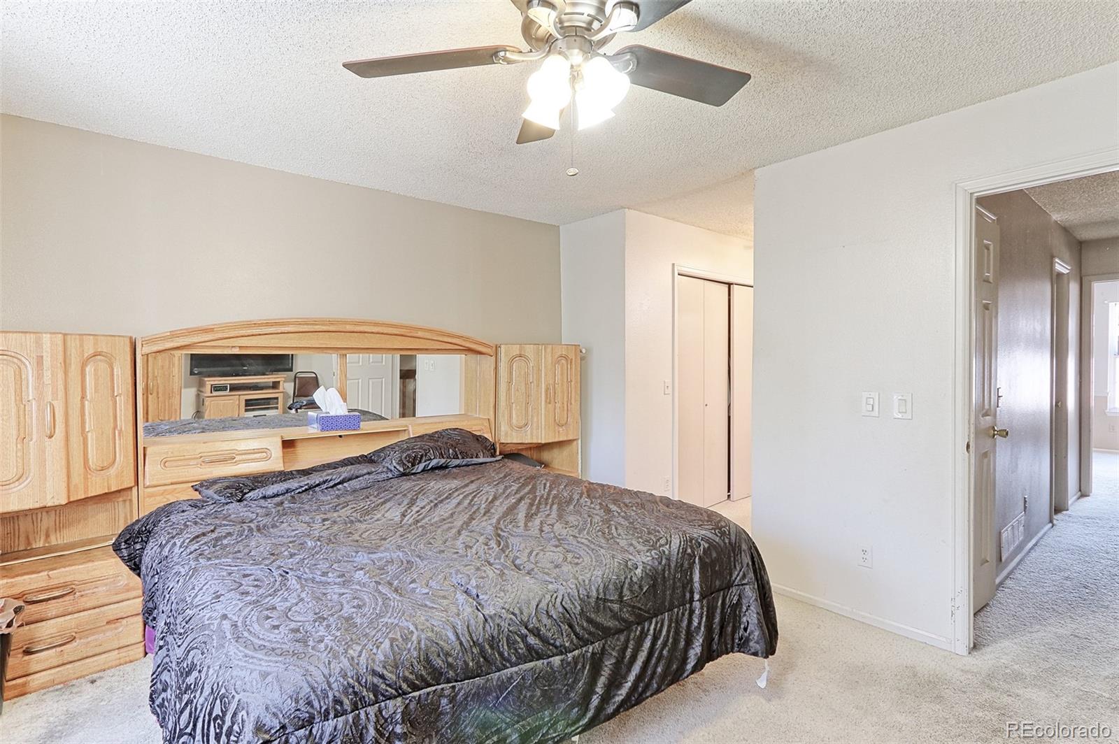 12133 Bannock Circle, Unit B Westminster, CO 80234 - Photo 8 of 14 a bedroom with a bed and a chandelier