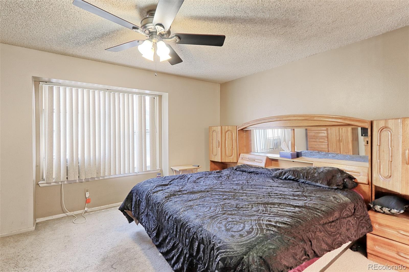 12133 Bannock Circle, Unit B Westminster, CO 80234 - Photo 9 of 14 a bedroom with a large bed and a chandelier