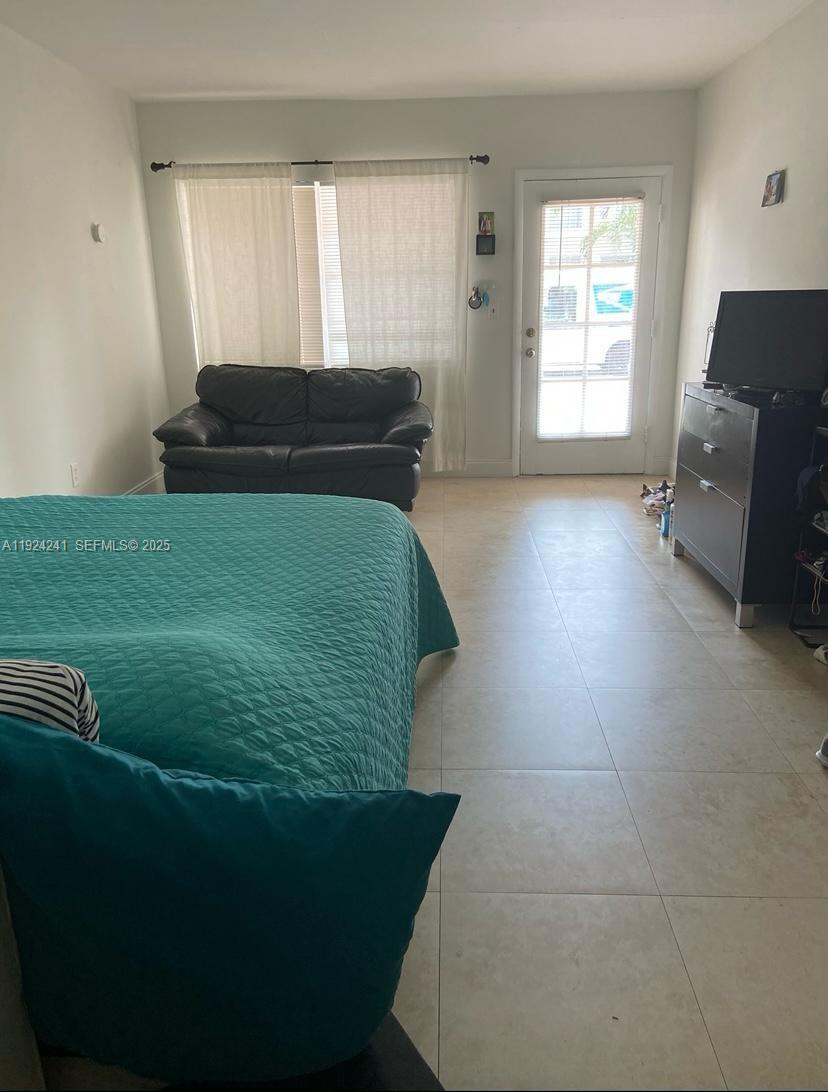 635 8th Street, Unit 103 Miami Beach, FL 33139 - Photo 2 of 6 a living room with furniture and a window