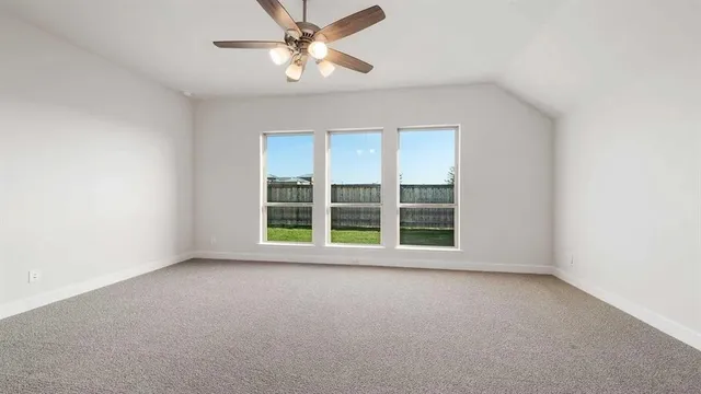 an empty room with a window and a ceiling fan
