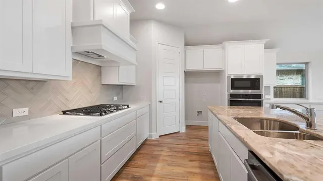 a kitchen that has a sink a stove and cabinets