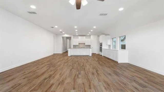 a view of a kitchen with wooden floor and a sink