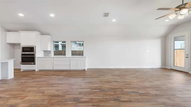 a view of empty room with wooden floor and fireplace