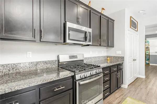 a kitchen with stainless steel appliances granite countertop a sink stove and microwave