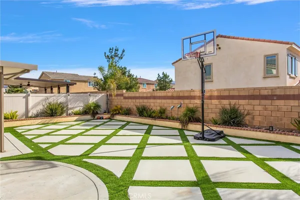 a patio with a table and chairs and potted plants