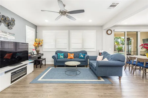 a living room with furniture a flat screen tv and a large window