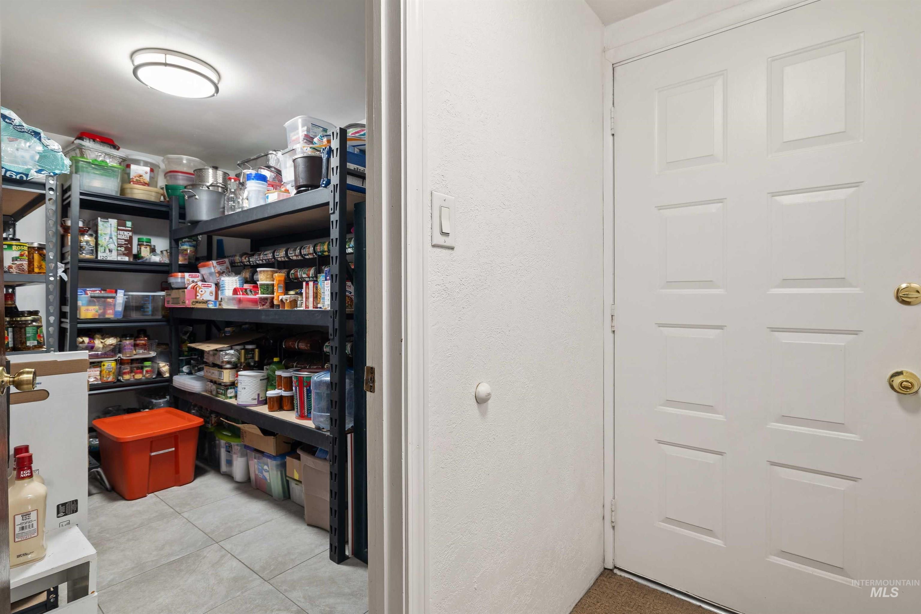 216 Ranch View Road West Jerome, ID 83338 - Photo 24 of 42 Pantry featuring multiple levels of shelving and tile flooring, with a flush-mount ceiling light