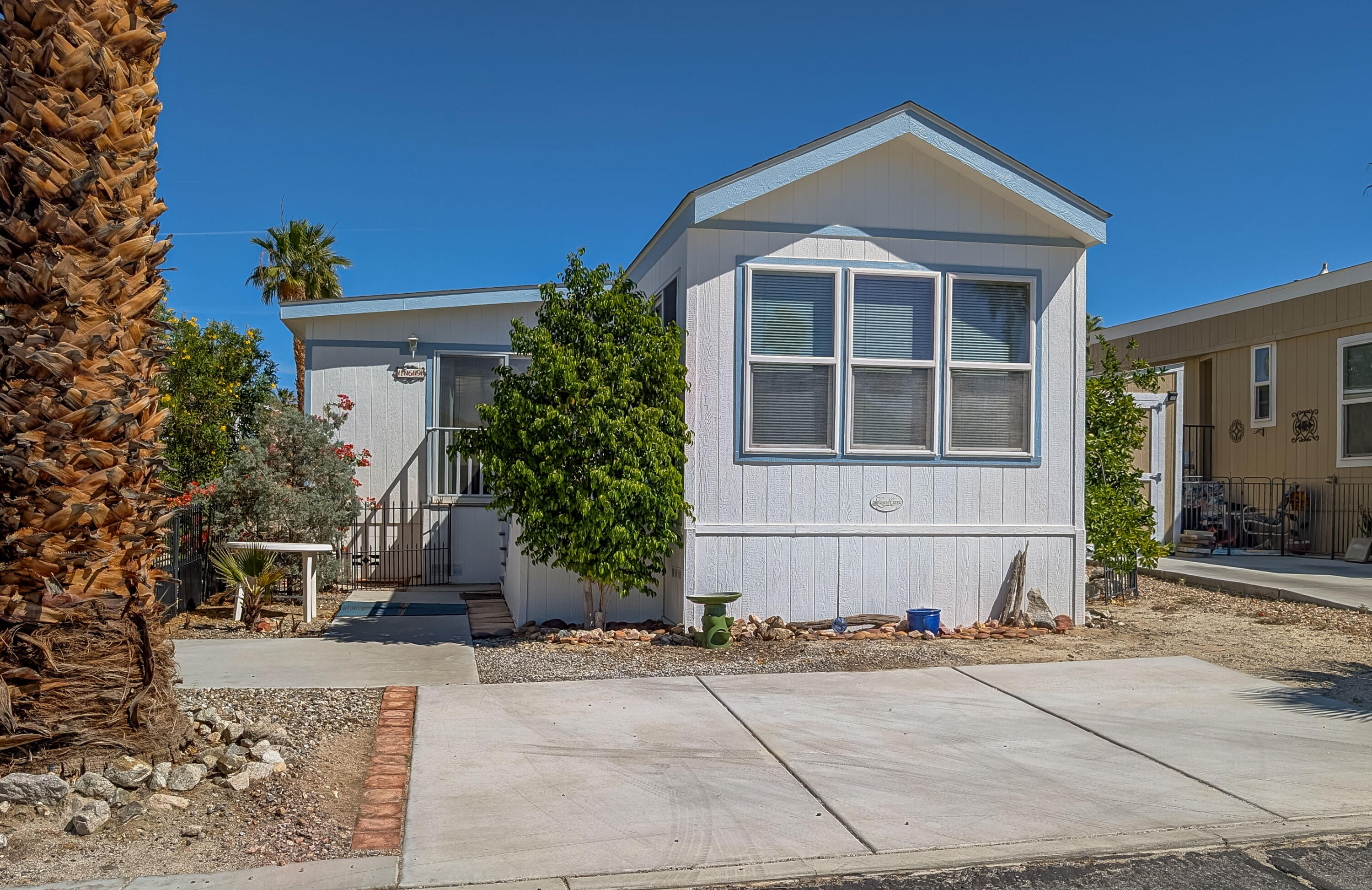 70200 Dillon Road, Unit 169 Desert Hot Springs, CA 92241 - Photo 2 of 25 a front view of a house with a yard