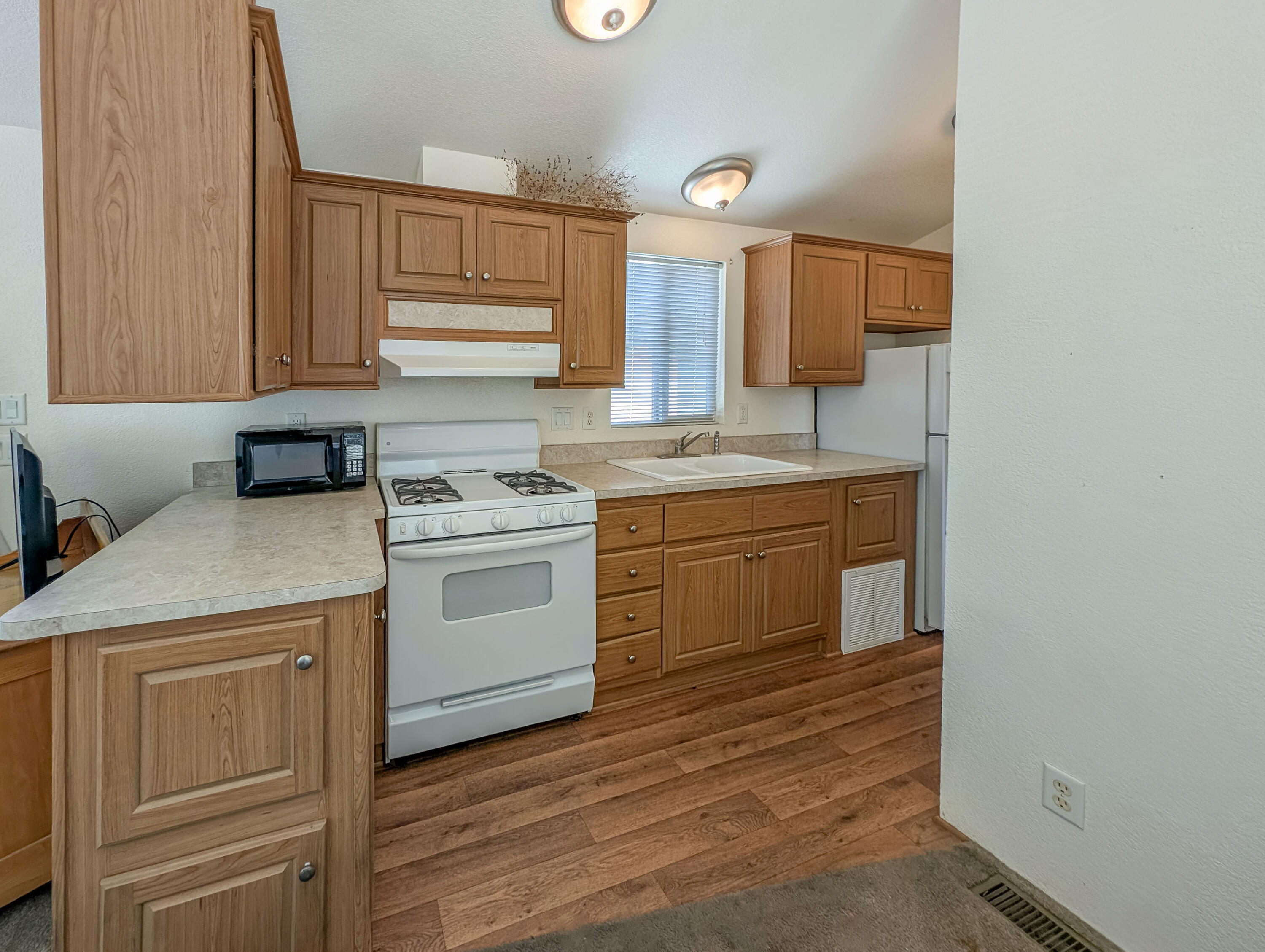 70200 Dillon Road, Unit 169 Desert Hot Springs, CA 92241 - Photo 9 of 25 a kitchen with a stove sink and cabinets