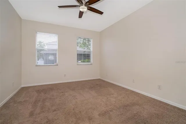 an empty room with a window and a fan