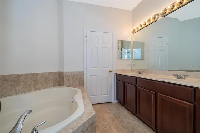 a bathroom with a tub sink and mirror