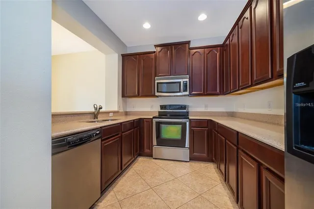 a kitchen with stainless steel appliances granite countertop wooden cabinets a sink and a stove